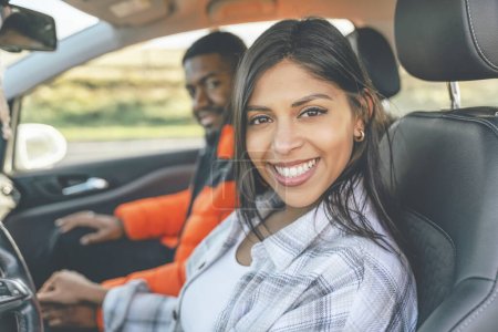 Beautiful happy young loving couple holding hands and smiling while sitting in their first car. Buy your first car concept toned image