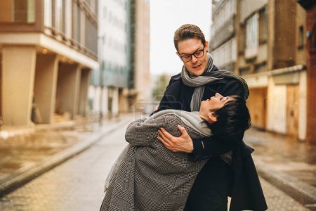 Handsome man and beautiful woman hugging each other as they walk around city, having fun time, lifstyle photo