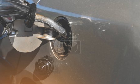 Un hombre llenando el tanque de combustible de su coche con combustible diesel en la gasolinera de cerca, como costo de combustible subiendo