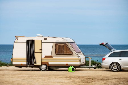Foto de Caravana remolque camping en la orilla del mar. Viaje de vacaciones con casa móvil. - Imagen libre de derechos