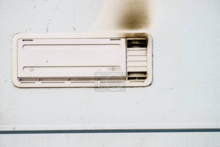 Foto de Detalle del auto autocaravana. Rejilla, placa de ventilación frigorífica ennegrecida por humo. Problema de gas. - Imagen libre de derechos