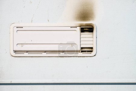 Foto de Detalle del auto autocaravana. Rejilla, placa de ventilación frigorífica ennegrecida por humo. Problema de gas. - Imagen libre de derechos