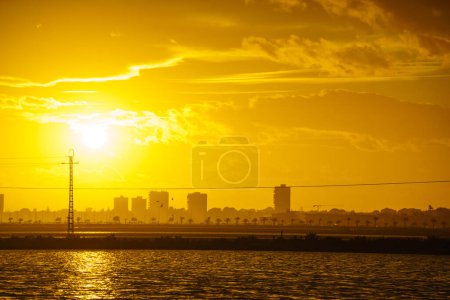Coucher de soleil sur la côte avec horizon urbain de la ville. Paysage côtier aux heures d'or, San Pedro del Pinatar, Murcie Espagne.