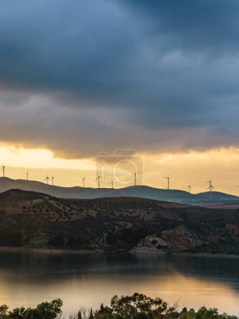 Andalucia sunset landscape with wind turbines on hills. Lake Embalse del Guadalhorce, Ardales Reservoir, province Malaga, Spain