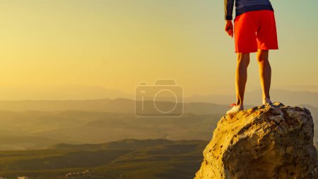 Tourist woman legs on rock viewpoint enjoying sunset landscape. Mesa Roldan location in province Almeria, Andalusia Spain. Cabo de Gata Natural Park.