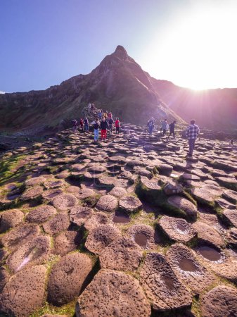 Foto de GIANTS CAUSEWAY, IRLANDA DEL NORTE, Reino Unido - 05 DE NOVIEMBRE DE 2022: Gente disfrutando de las 40000 columnas de basalto entrelazadas. - Imagen libre de derechos