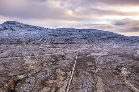 Téléchargez les photos : The R251 next to the snow covered Mount Errigal, the highest mountain in Donegal - Ireland - en image libre de droit
