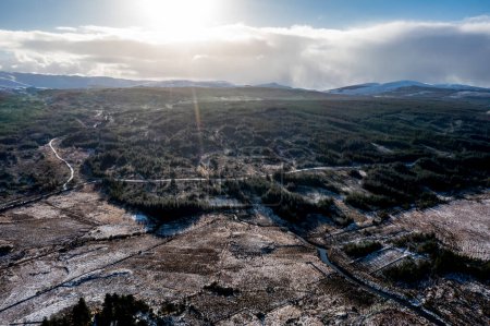 Téléchargez les photos : Aerial view of snow covered Gweebarra River between Doochary and Lettermacaward in Donegal - Ireland - The site of the new Cloughercor wind farm in the background. - en image libre de droit
