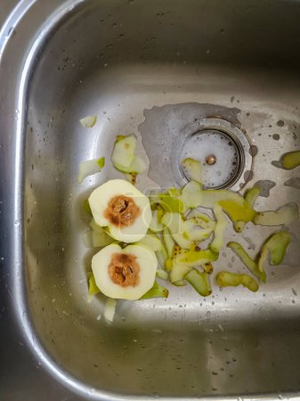 Photo for Apple that is rotten in the middle in sink. - Royalty Free Image