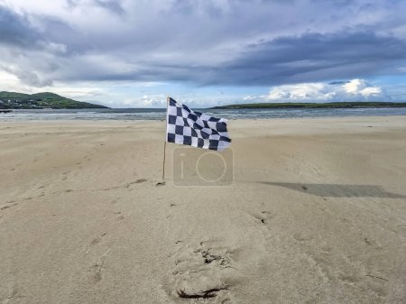 Photo for Checked white and flag racing flag on Narin strand by Portnoo, County Donegal, Ireland. - Royalty Free Image