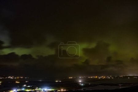 Foto de Noche de una de las Aurora Boreal más fuertes sobre Dungloe y la isla de Arranmore en el Condado de Donegal - Irlanda. - Imagen libre de derechos
