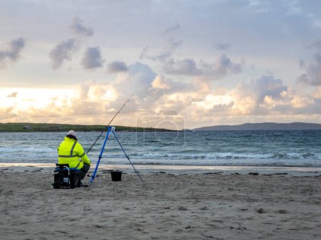 20 hombre están compitiendo en un concurso de pesca en la playa
