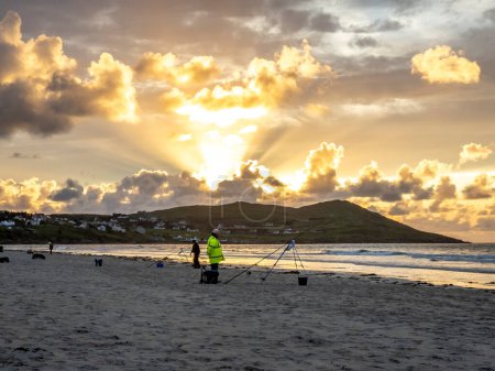 Téléchargez les photos : 20 hommes sont en compétition dans une compétition de pêche sur la plage - en image libre de droit