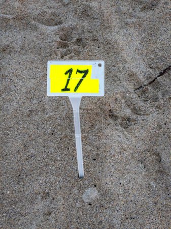Schild mit der Nummer 17 am Sandstrand.