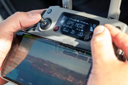 Téléchargez les photos : DOWNINGS, IRLANDE - 31 JUILLET 2022 : Homme tenant la télécommande d'un drone. - en image libre de droit
