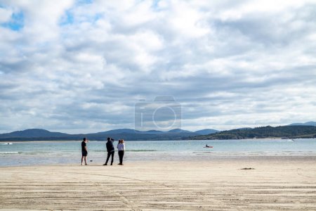 Foto de DOWNINGS, IRLANDA - 31 DE JULIO DE 2022: Los turistas disfrutan de la playa. - Imagen libre de derechos
