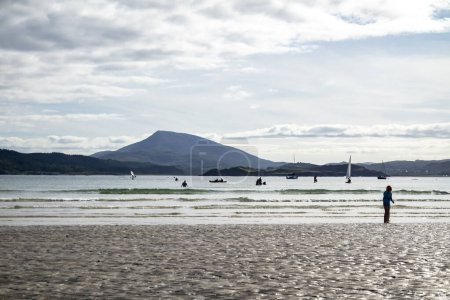 Foto de DOWNINGS, IRLANDA - 31 DE JULIO DE 2022: Los turistas disfrutan de la playa. - Imagen libre de derechos
