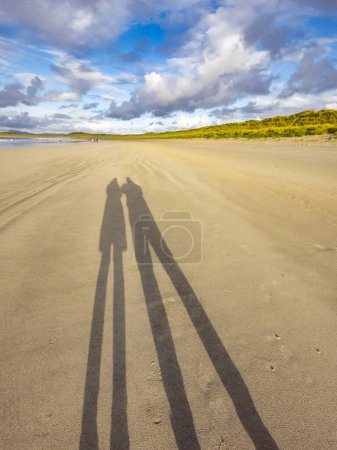 Foto de Sombra de pareja disfrutando de la playa. - Imagen libre de derechos