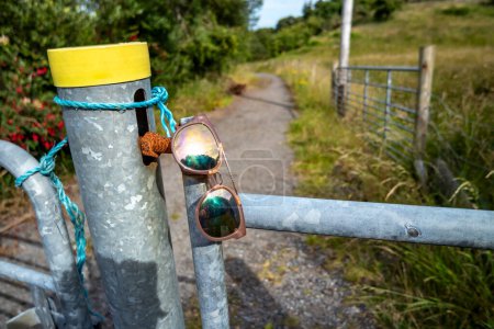 Photo for Sun glasses resting on a gate in rural Ireland. - Royalty Free Image