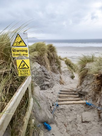 Schilder warnen vor plötzlichem Absturz und steilem Hang am Strand von Dooey bei Lettermacaward in der Grafschaft Donegal - Irland