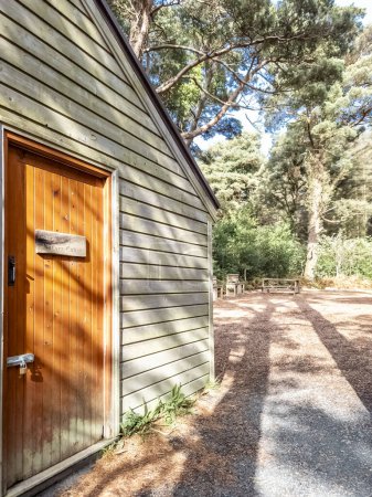 Holzhaus in einem Wald in der Grafschaft Donegal - Irland, Schilder erklären auf Irisch und Englisch: Nature Cabin.