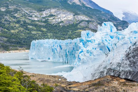 Poderoso hielo turquesa del glaciar Perito Moreno y un pequeño barco turístico a la derecha. Parque Nacional Los Glaciares, Argentina
