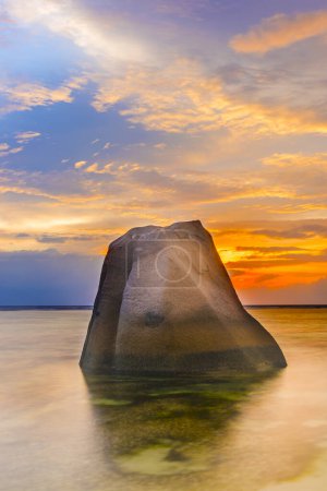Téléchargez les photos : Rocher solitaire reflétant dans la mer pendant le beau coucher de soleil vibrant. Île de La Digue, Seychelles - en image libre de droit