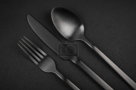 Photo for Black Silverware Set. Fork, knife and spoon on black backgroun - Royalty Free Image