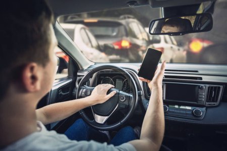 Photo for Furious man driver honking the car horn angry on the traffic jam ahead. Aggressive guy unsafe driving while using his phone in front of the steering wheel, violating the rules - Royalty Free Image