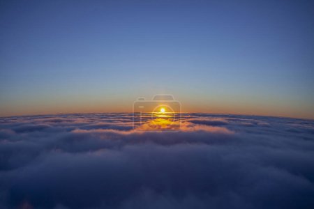 Téléchargez les photos : Coucher de soleil au-dessus de la mer de nuages. ciel bleu paysage - en image libre de droit