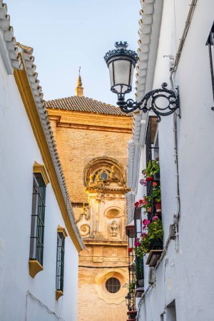 Narrow street with white buildings leading to medieval cathedral in Carmona, Andalusia, Spain, Europe