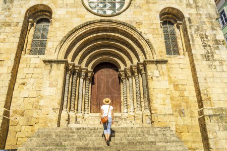 Photo for Woman visiting a romanesque church, Coimbra, Igreja de Sao Tiago - Royalty Free Image