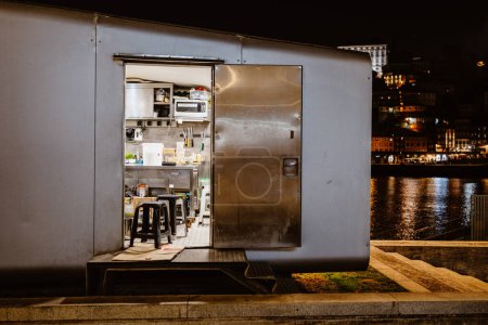Téléchargez les photos : Cuisine dans un étal près de la rivière la nuit, Porto, Portugal - en image libre de droit