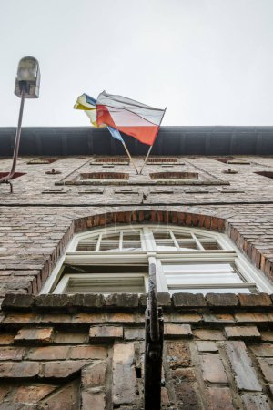 Bandera polaca y ucraniana ondeando juntos en casa de ladrillo en Katowice Nikiszowiec, sur de Polonia