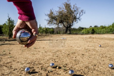 Téléchargez les photos : Jouer à la boule au Portugal. La main de l'homme au premier plan. - en image libre de droit