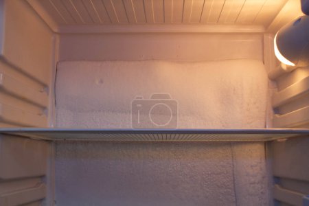 Photo for Broken refrigerator with snow inside need repairing. Icing on the back wall of the refrigerator. Freezer repaired in a service workshop. Fridge Inside view. Repair of faulty refrigeration equipment - Royalty Free Image
