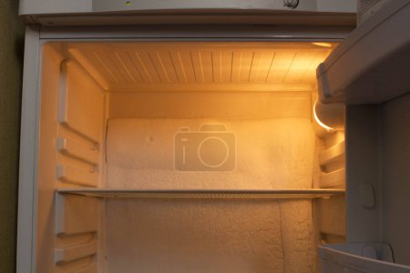 Photo for Broken refrigerator with snow inside need repairing. Icing on the back wall of the refrigerator. Freezer repaired in a service workshop. Fridge Inside view. Repair of faulty refrigeration equipment - Royalty Free Image