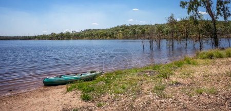 Photo for A kayak on the edge of the calm waters of Lake Boondooma or Boondooma Dam on the Boyne River near Proston in the South Burnett Region, Queensland, Australia. - Royalty Free Image