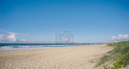 Ein sonniger Tag am Strand mit sandigem Vorland, krachenden Brandungswellen und blauem Himmel bei Kawana an der Sunshine Coast in Queensland Australien