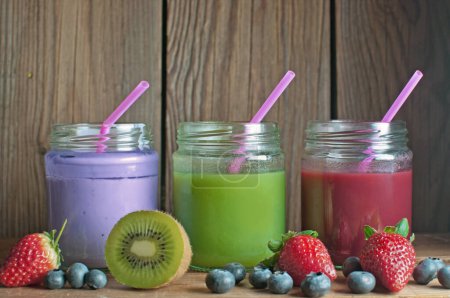 Photo for Fruit smoothies on a wooden table with space for text - Royalty Free Image