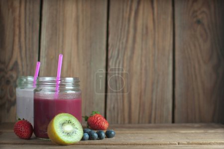 Photo for Fruit smoothies on a wooden table with space for text - Royalty Free Image