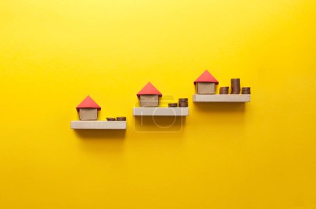 Foto de Escaleras de propiedad con casa de origami en miniatura que conducen a cantidades crecientes de dinero - Imagen libre de derechos