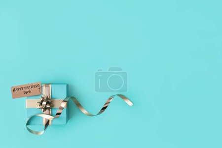 Téléchargez les photos : Pères jour boîte cadeau saisonnier enveloppé avec ruban d'or décoratif arc - en image libre de droit
