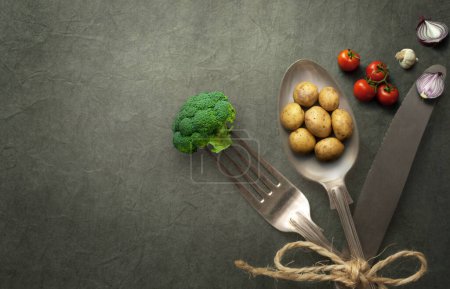 Téléchargez les photos : Pommes de terre miniatures, oignons et brocolis sur coutellerie, concept d'aliments biologiques - en image libre de droit