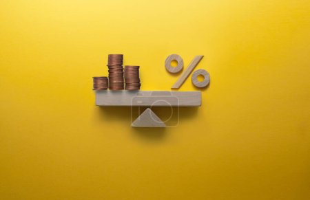 Photo for Coins and percentage sign balanced on a seesaw, interest rates; profit investment concept - Royalty Free Image