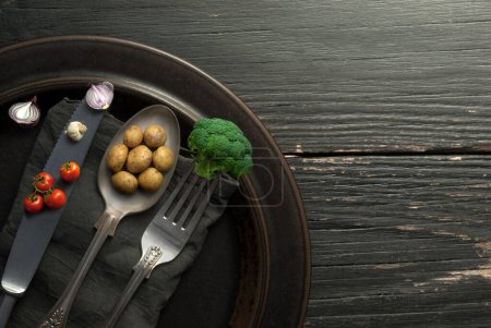 Téléchargez les photos : Pommes de terre miniatures, oignons et brocolis sur coutellerie, concept d'aliments biologiques - en image libre de droit