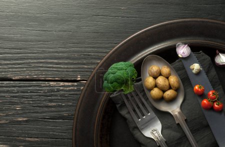 Photo for Miniature potatoes, onions and broccoli on cutlery, organic food concept - Royalty Free Image