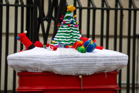Téléchargez les photos : London, UK - February 5th 2024: Close-up of a Christmas-themed knitted Post Box topper in London, UK. - en image libre de droit