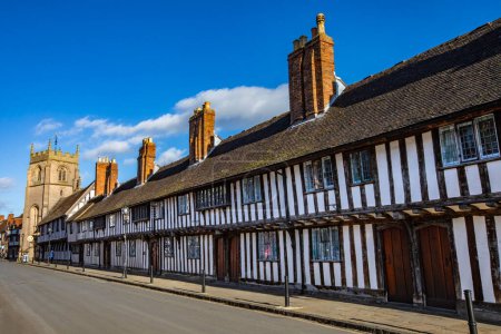 Hermosas casas adosadas del siglo XV en la histórica ciudad de Stratford-Upon-Avon, Reino Unido. La torre de la Capilla del Gremio se puede ver en la distancia.