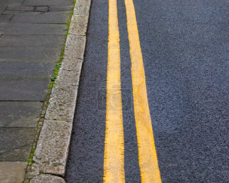 Téléchargez les photos : Gros plan des doubles lignes jaunes sur une route. - en image libre de droit